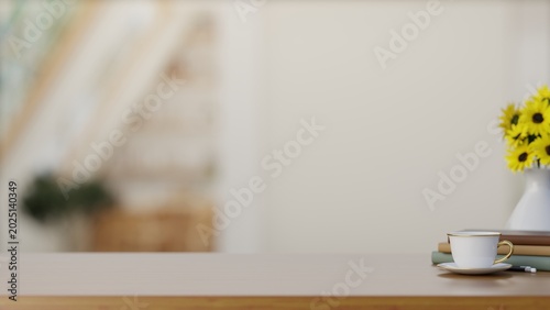 Coffee or tea cup beside books and sunflower vase on wooden countertop table in the white wall room.