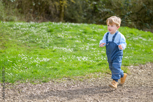 Toddler running across sunny playground