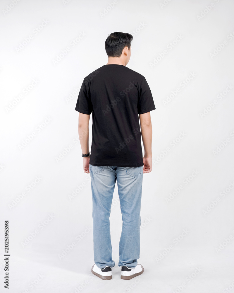 Fototapeta premium Male body wearing black t-shirt and blue jeans seen from behind and isolated on white background
