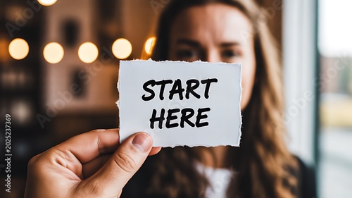 Person holding start here note for motivation and new beginning concept