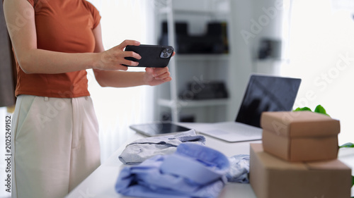 Fotografía Asian woman entrepreneur live streaming product showcase using smartphone taking