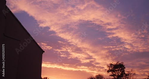 Looking up in wonder at sunrise dawn beautiful sky clouds between buildings