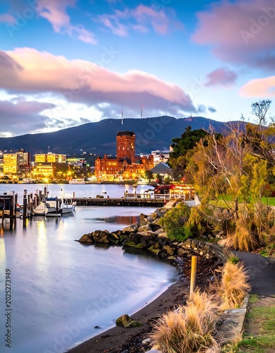 A serene waterfront scene with a cityscape and docked boats