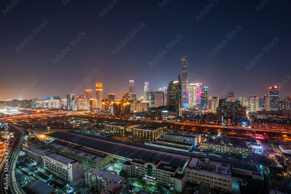 Fototapeta premium After a snowfall in China, Beijing's CBD, including the China Zun building, boasts a vibrant cityscape and a panoramic view of the bustling central business district at night.
