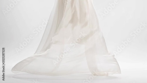 The video showcases a delicate fabric, likely a sheer curtain or piece of cloth, being lifted or moved in slow motion
