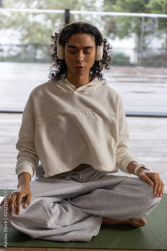 Fototapeta premium Nonbinary person meditating on wet deck, smartwatch activating animated heart rate rings for health