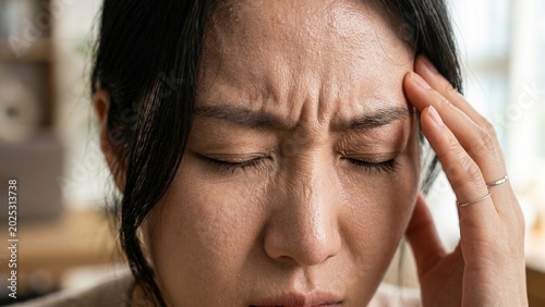 頭痛で頭を押さえる患者 健康管理と医療をイメージしたコンセプト
