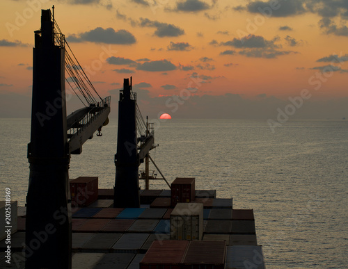 Tableau sur toile A merchant ship underway at sea in the evening
