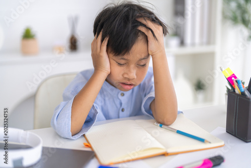 Tableau sur toile Asian boy stressed homework studying with hands on head, tired expression shows