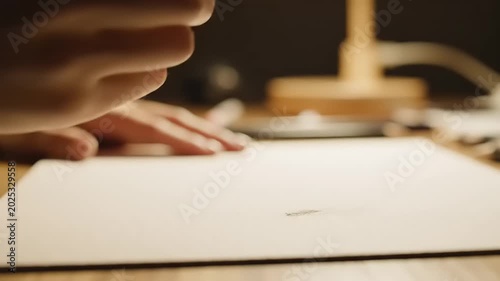 Close-up of a hand writing with a pencil on white paper, artistic concept.