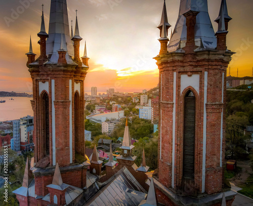 Bild auf Leinwand Neo-Gothic towers of the Catholic Church of the Most Holy Mother of God above Vladivostok, Russia overlooking Golden Horn Bay cityscape