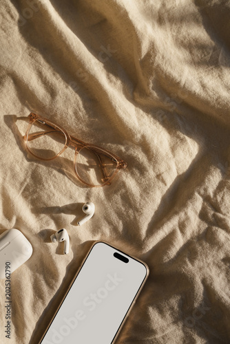 Flat Lay of Phone, Glasses, and Earbuds