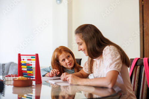 Mother helping daughter with math homework