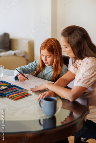 Mother helping daughter with art project for school