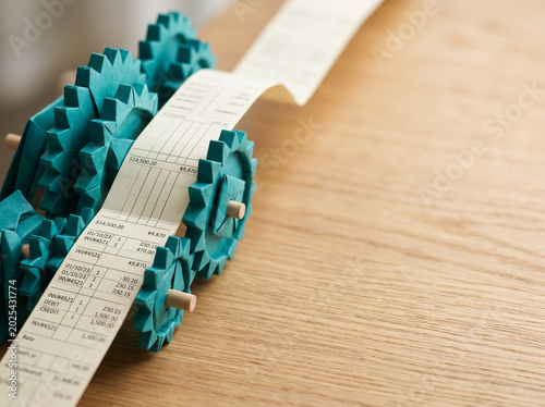 Ai agent for business financial paper roll, calculator gear, data tape, wooden desk, teal