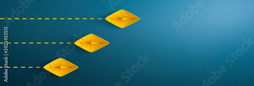 Yellow paper ship on blue background, Business competition concept. copy space
