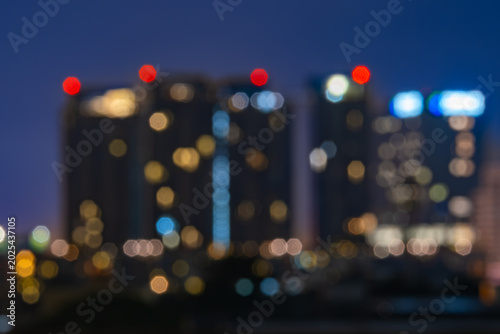 Billede på lærred Abstract city lights bokeh at night with blurred skyscrapers, glowing patterns, and vibrant urban skyline—ideal for wallpaper, background, and advertising design