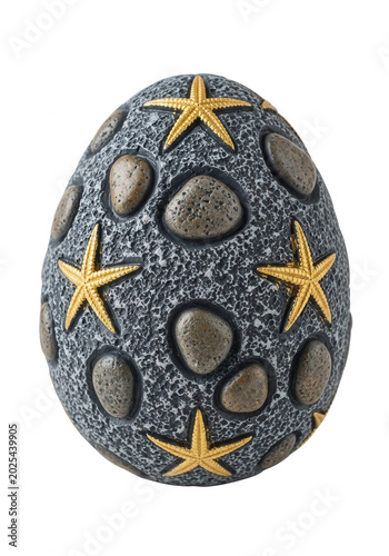 Decorative egg with gold star accents and pebbles