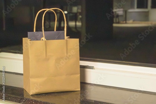Konstfotografi Brown paper bag on a windowsill in a dimly lit room during the evening