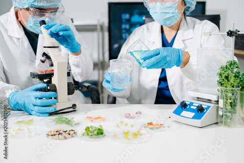 Female nutritionist in lab coat analyzing food and writing in notebook. Healthy eating  organic testing  and nutrition science