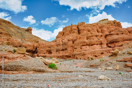 Φωτογραφία Vast sandstone cliffs under a vibrant blue sky with scattered clouds