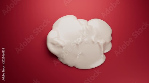 Creamy white liquid spreading on red surface