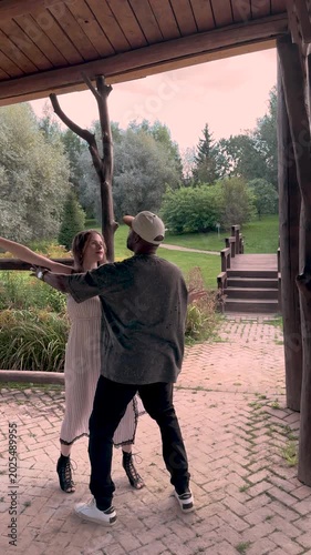 People dancing bachata outdoors, Passionate couple in stylish summer outfits, full length partner dance with sensual movement