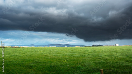 Quadro su tela Atmospheric rural landscape of Dingle Ireland with heavy gray clouds and sunlit