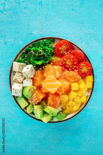 Salmon poke bowl with mango, avocado, tofu, wakame, cherry tomatoes
