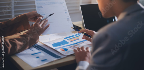 The businesswoman is using a white calculator to check company financial information, she is checking company financial information from the documents provided by the finance department.