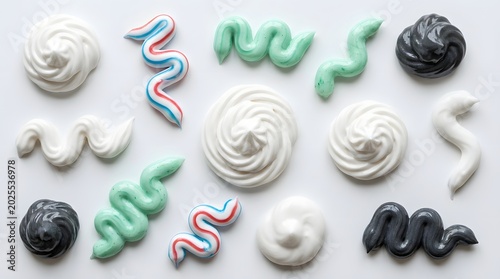 A flat lay composition of colorful meringue cookies and candy swirls arranged on a white background