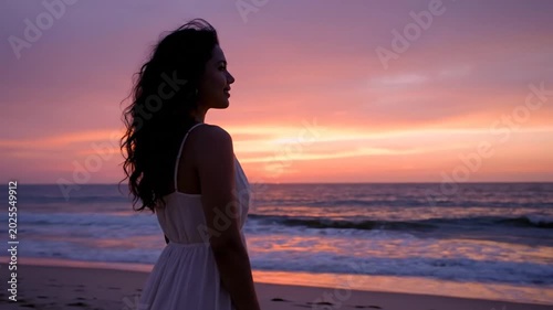 Silhouette of woman watching colorful sunset at serene beach