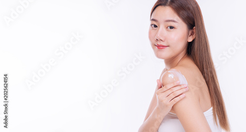 Tableau sur toile Beautiful young Asian woman applying moisturizing body lotion on her shoulder