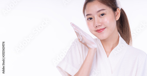 Quadro su tela Beautiful young Asian woman in white bathrobe showing soft soap foam on her hand