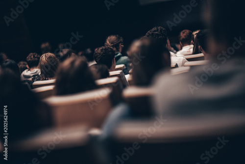 Rear view of unrecognizable people in audience at the conference hall. Business and entrepreneurship symposium