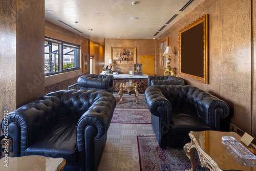 Sophisticated cigar lounge with black leather chesterfield sofas