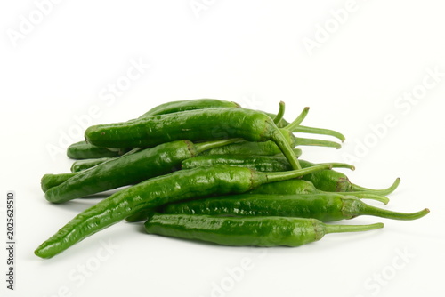 Fotografija Fresh green chili peppers piled on a white background for cooking ingredients