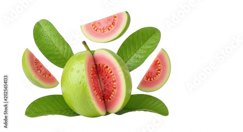 Fresh pink guava fruit with sliced segments and green leaves isolated on a solid black background