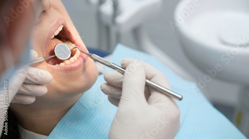 Professional dentist performing a dental checkup on a patient using specialized tools in a clinic.