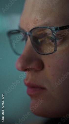 In a quiet office, a programmer wearing glasses works at his desktop PC, harnessing artificial intelligence to generate code instantly, boosting productivity and streamlining development