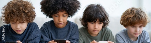 Close up of four focused kids using mobile phones on couch for screen learning and gaming background suitable for education design and digital safety campaigns