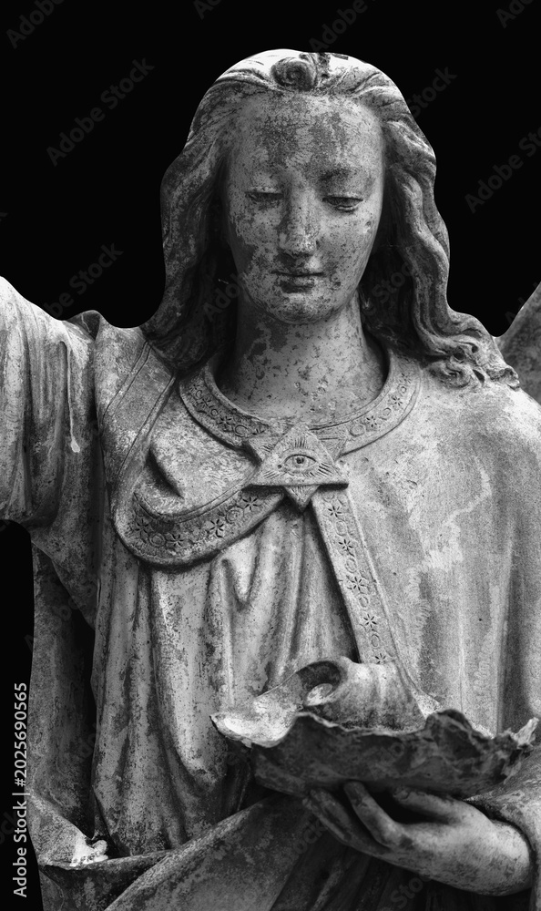 Fototapeta premium Ancient angel statue holding broken object in dramatic monochrome composition