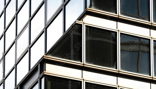 Displaying office corner showing glazed bays at exterior facade with glass panes, mullions, grime