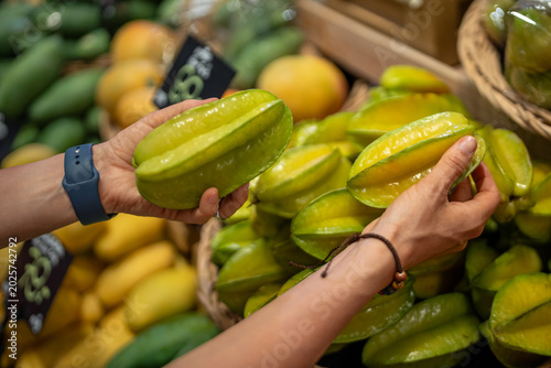 Konstfotografi Customer choosing carambola for buying