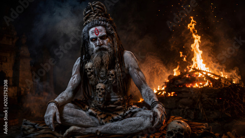 Aghori Sadhu Sitting in Meditation with 
Dramatic Blue and Fire Tones, Powerful Hindu 
Holy Man Varanasi Dark Spiritual Art