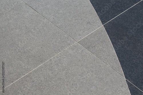 Abstract pattern of contrasting grey and dark grey textured tiles with clean grout lines
