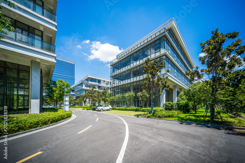 Modern Office Building Complex Surrounded by Lush Greenery and Clear Blue Sky