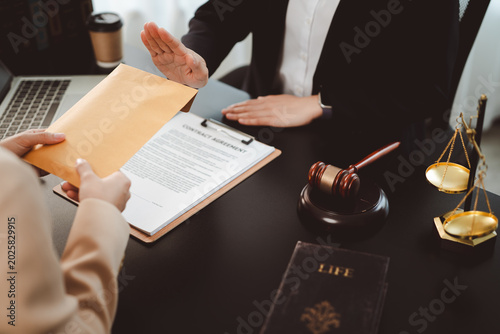 Businesswoman's hand firmly rejecting a cash bribe in a brown envelope over a contract, symbolizing integrity, anti-corruption stance and ethical refusal in a corporate legal setting