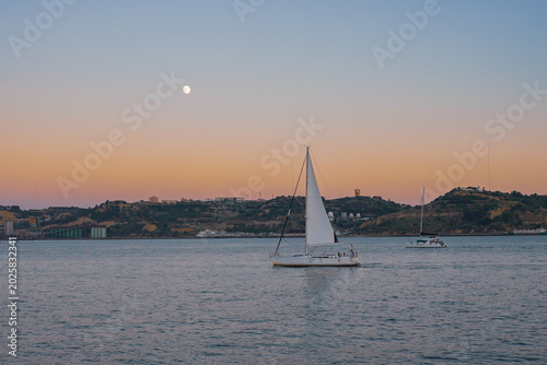 A boat sailing off the coast of Lisbon, Portugal, on a hot, windy afternoon.