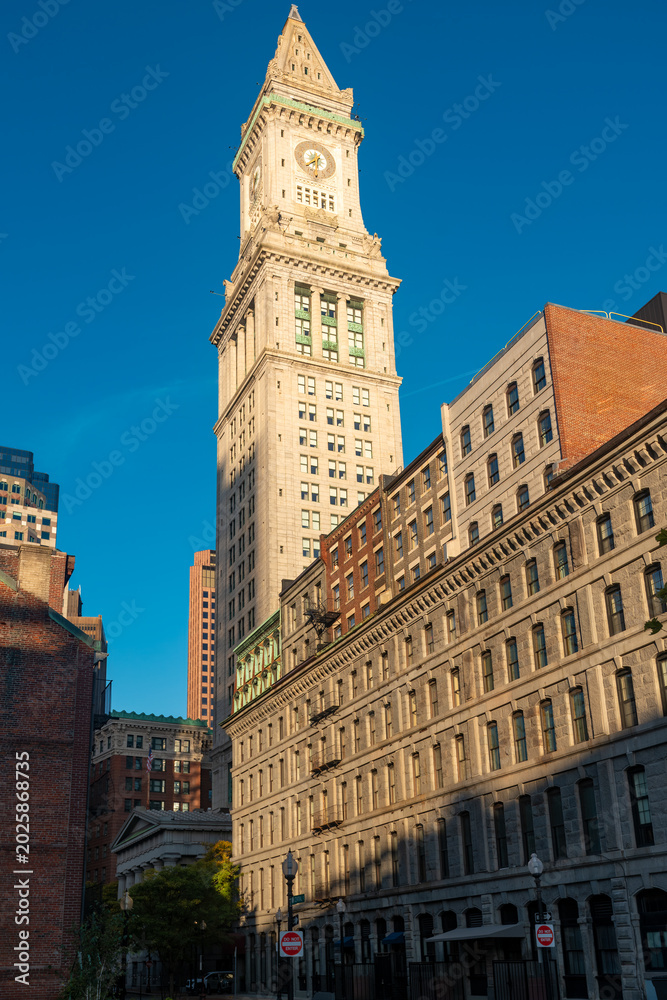 Fototapeta premium Vertical view of the Boston Custom house tower at downtown showing the iconic clock and neoclassical architecture alongside classic facades of the city.